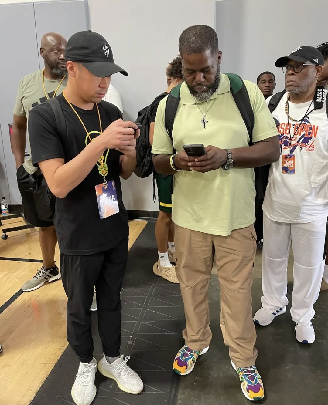 Coach Harris courtside with basketball media and players